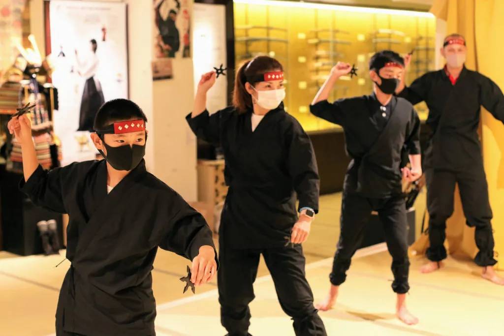 woman and kids holding shuriken in ninja class